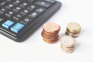 Stacked coins next to a calculator