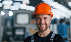 Young man smiling with orange hard hat on