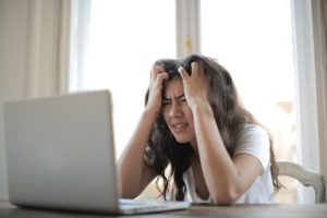 Person stressed working on a laptop