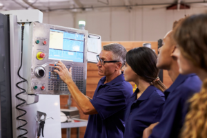 Apprentice mechanics listening to mentor