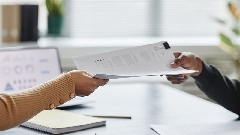 Person passing CV over to another person