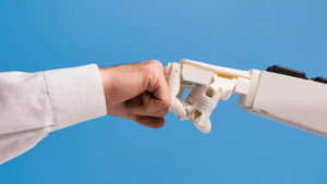 Human fist pressing against a robotic fist