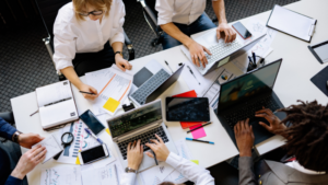 Busy workplace with several people working on laptops