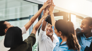 Group of professionals with their hands together, raised in the air