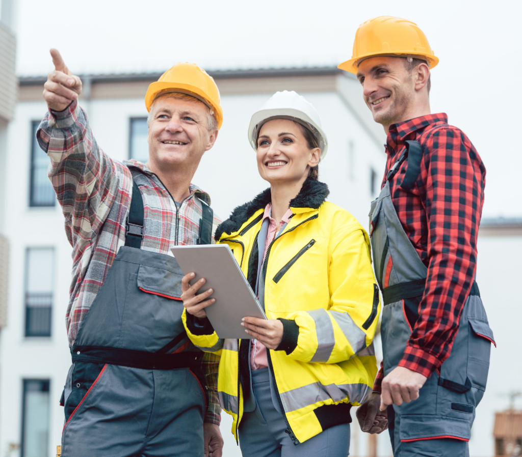 A female construction worker stood with two male construction workers smiling on a building site