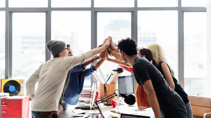 Group of young professionals huddling together in the workplace
