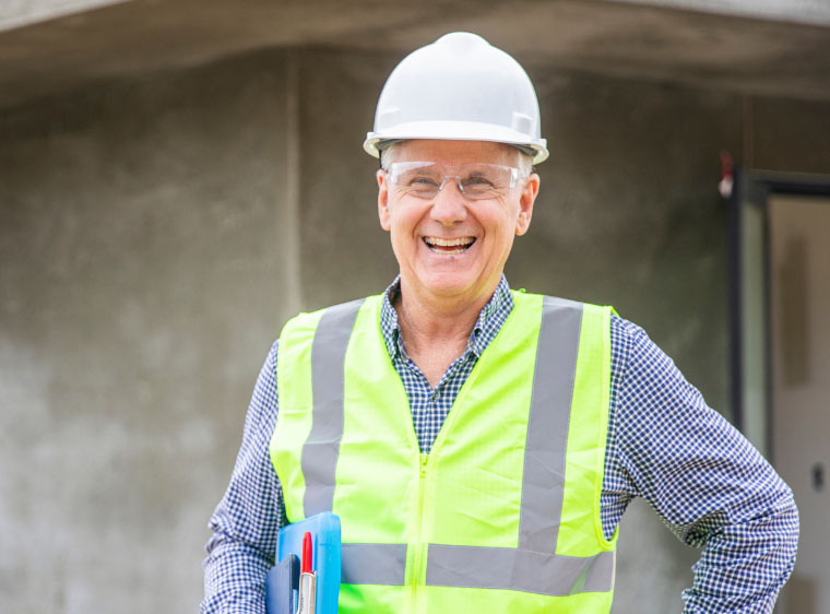 Man smiling on construction site in hardhat