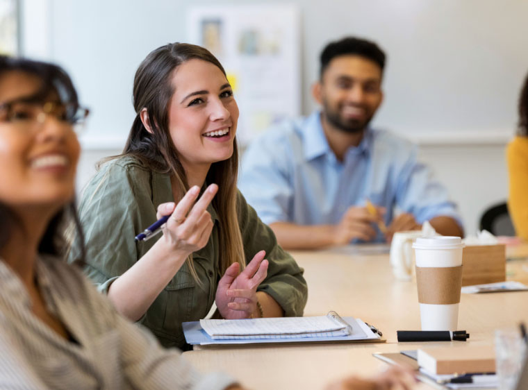 Young professional sat at roundtable smiling