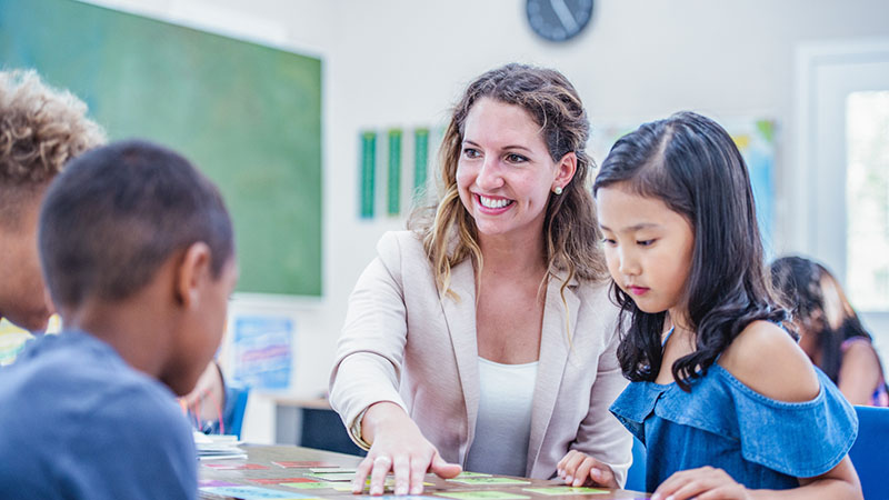 Teacher sat with group of students