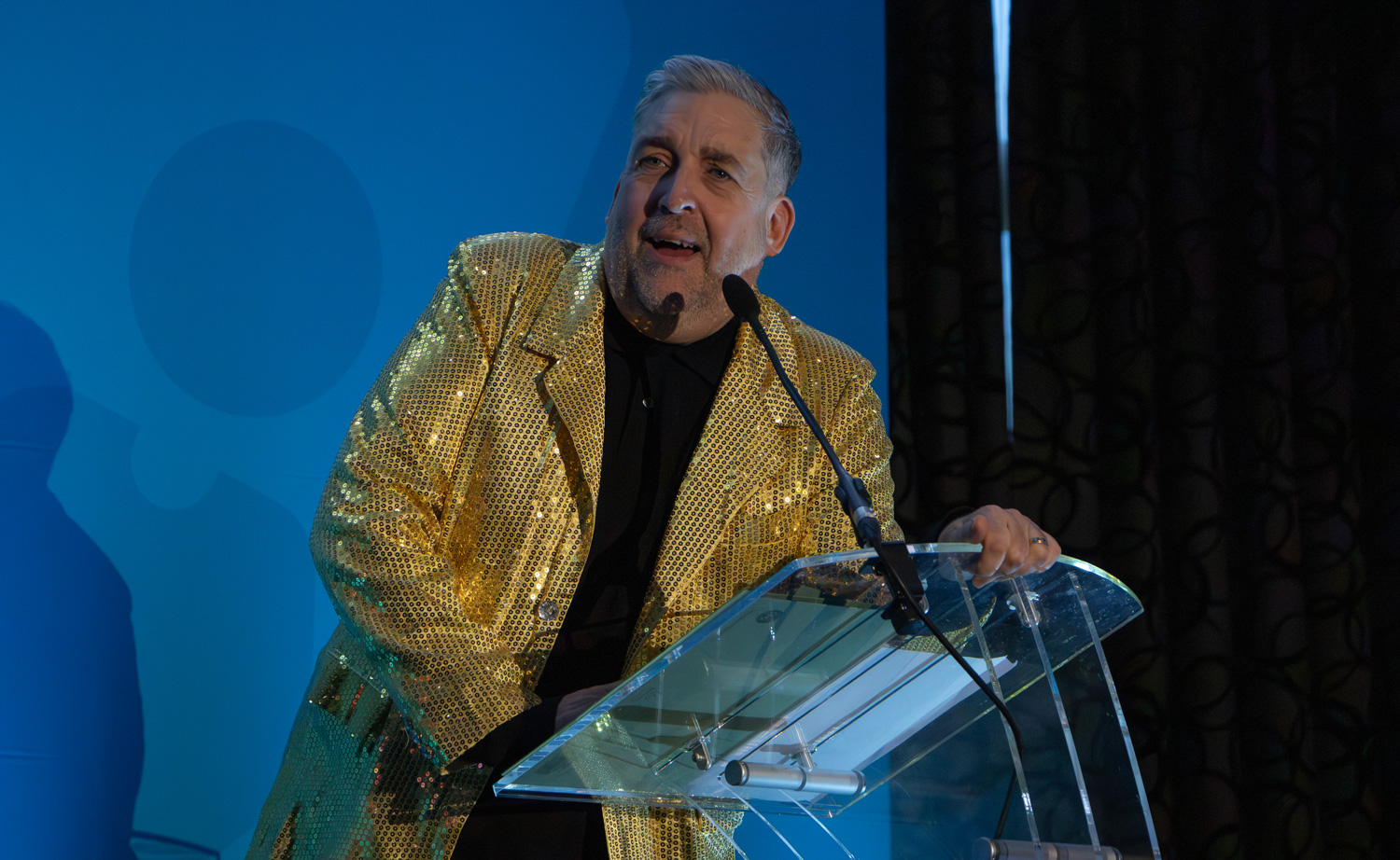 Paul Brammer in golden jacket at annual conference